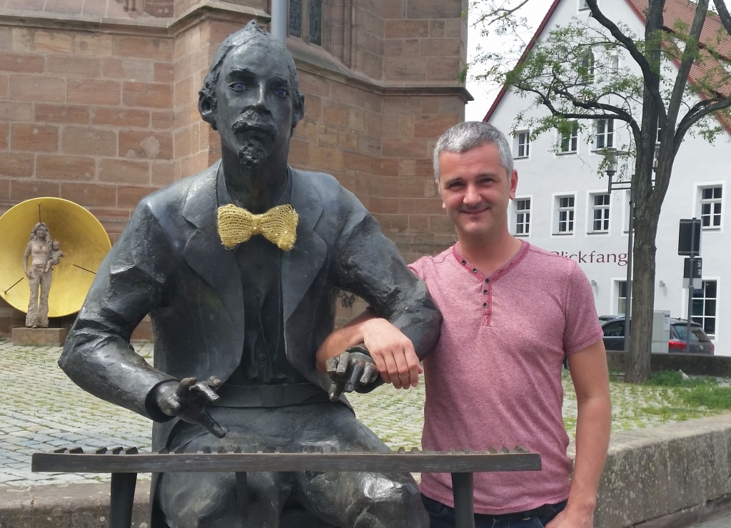 Der Pianist und Autor Daniel Grimwood neben der in der Geburtsstadt Schwabach stehenden Bronzeplastik Adolph von Henselts.